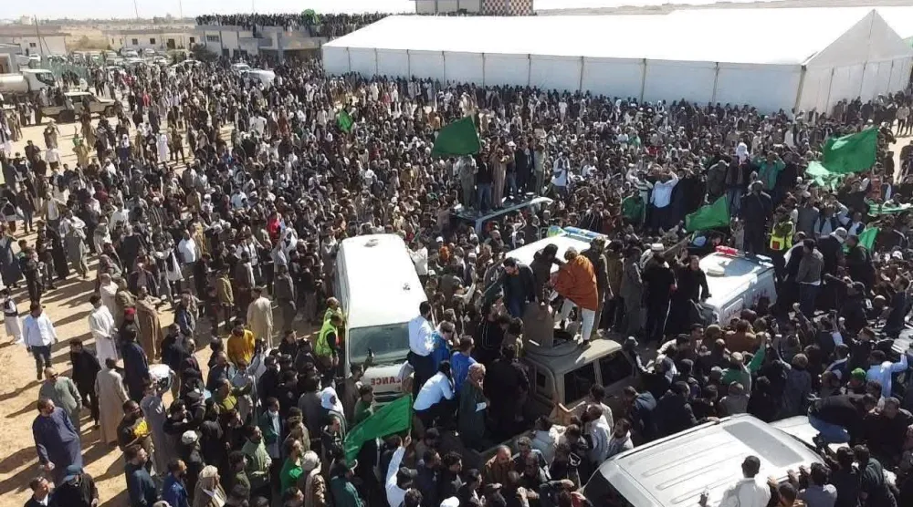 جموع من المشيّعين يطوّقون سيارة الإسعاف التي تحمل جثمان سيف القذافي في مطار بني وليد (صفحات مؤيدة لسيف)