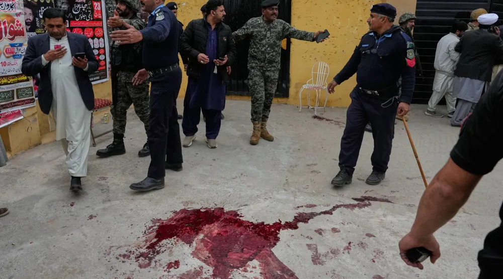 عناصر الأمن الباكستاني يبعدون الناس عن موقع الانفجار في إسلام آباد الجمعة (أ.ب)