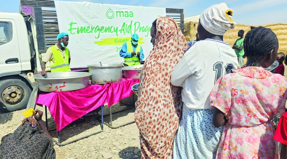 
نازحون سودانيون ينتظرون الحصول على الطعام في مخيم «أبو النجا» بولاية القضارف أمس (أ.ف.ب)