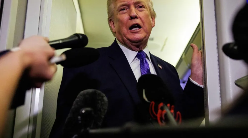 الرئيس الأميركي دونالد ترمب يتحدث إلى الصحافيين على متن الطائرة الرئاسية «إير فورس وان» في طريقه إلى بالم بيتش بولاية فلوريدا (أ.ف.ب) 