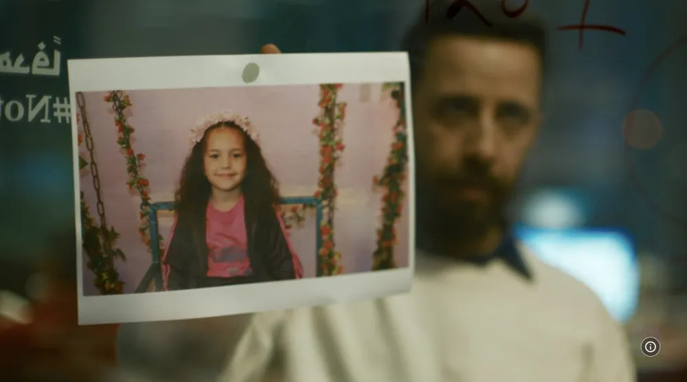 الممثل معتز ملحيس وأمامه صورة الطفلة هند رجب في مشهد من الفيلم