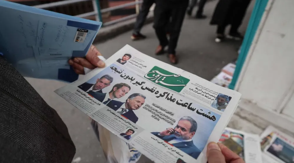 Tahran’da bir adam, ABD ile yapılan ilk tur müzakerelerini konu alan bir gazetenin ön sayfasını okuyor. (AFP)