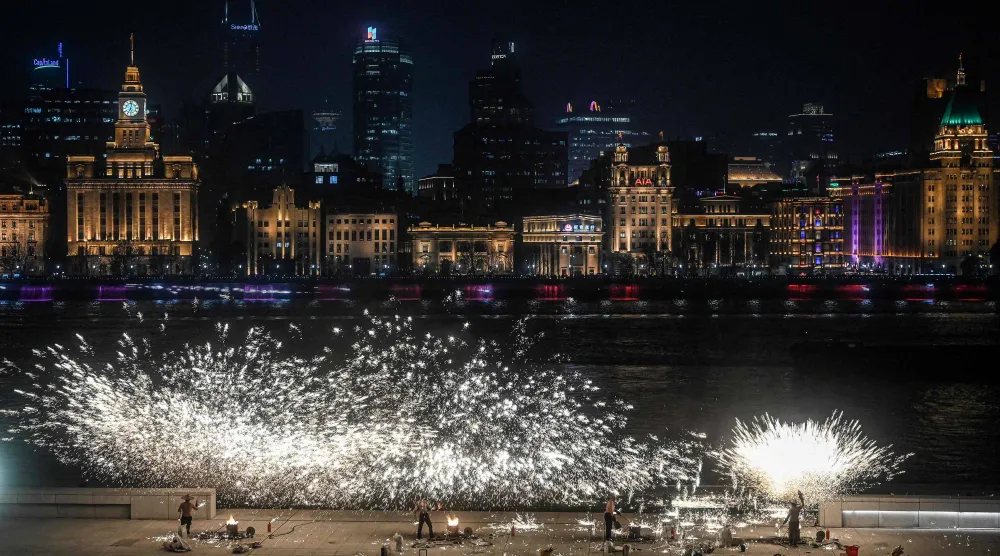 Performers throw molten iron to create sparks during a performance on the Bund promenade along the Huangpu river, ahead of the upcoming Lunar New Year of the Horse in Shanghai on February 2, 2026. (AFP) 