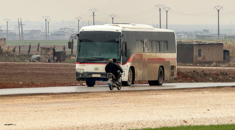 حافلة ضمن قافلة أميركية تنقل محتجزين من «داعش» على طريق في ضواحي الحسكة شمال شرقي سوريا يوم 7 فبراير 2026 (أ.ف.ب)