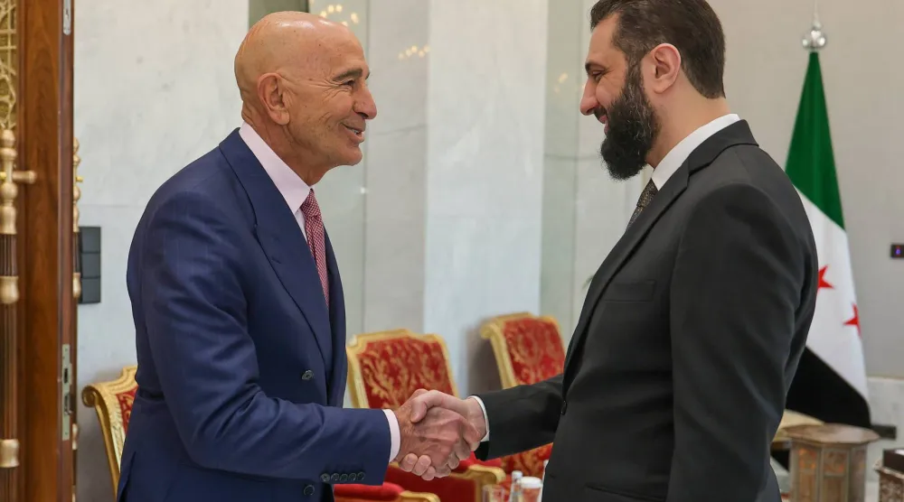 الرئيس السوري أحمد الشرع يصافح المبعوث الأميركي توماس برّاك (د.ب.أ)