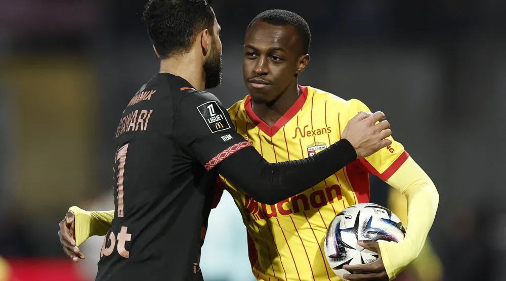 سعود عبد الحميد «يمين» يصافح موسى التعمري بعد نهاية مباراة لانس ورين (رويترز)