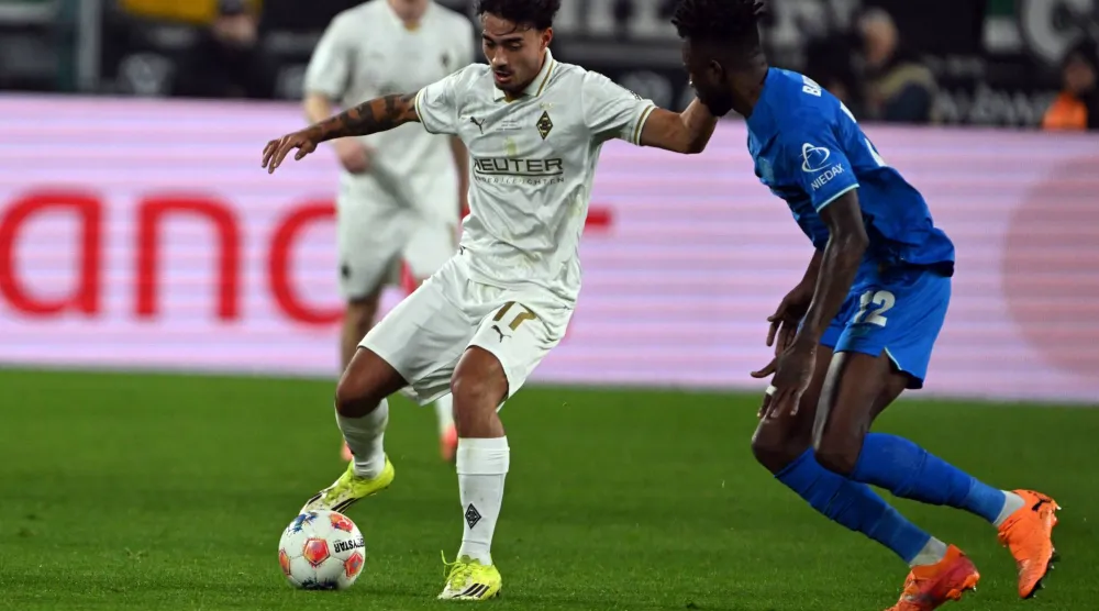 ينس كاستروب لاعب بوروسيا مونشنغلادباخ وإدمون تابسوبا لاعب باير ليفركوزن يتنافسان على الكرة (د.ب.أ)