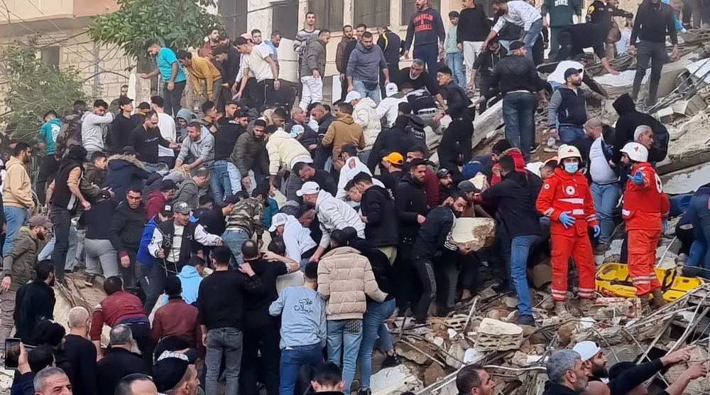 عمال إنقاذ يبحثون عن ناجين بين أنقاض مبنى انهار في مدينة طرابلس شمال لبنان (أ.ب)