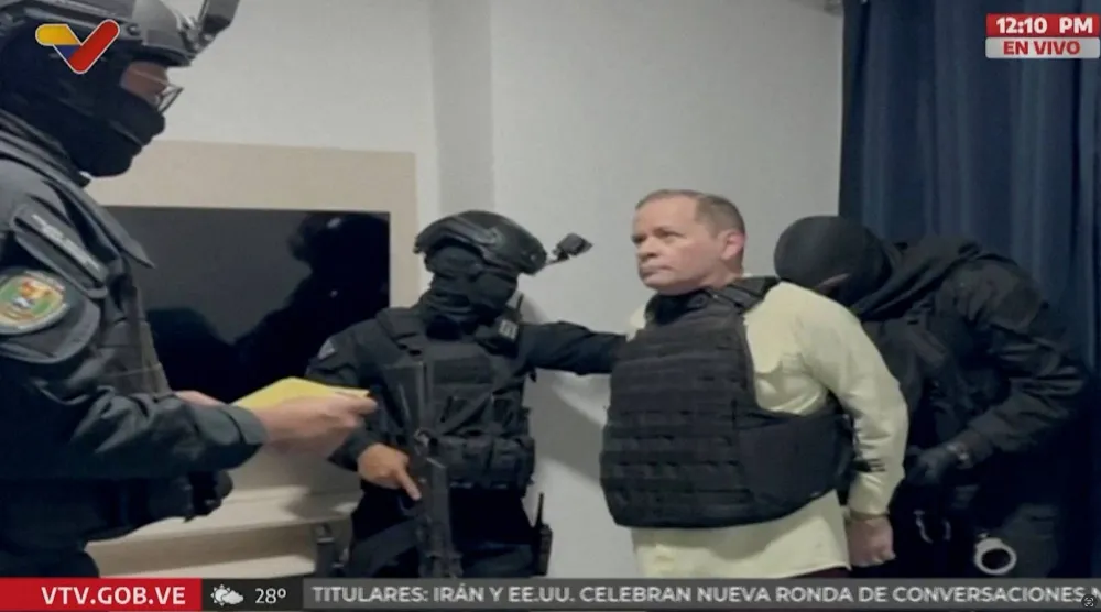 المعارض الفنزويلي خوان بابلو غوانيبا مرتدياً سترة واقية من الرصاص أثناء تكبيله بالأصفاد بعد توقيفه على يد قوات إنفاذ القانون الفنزويلي (رويترز)