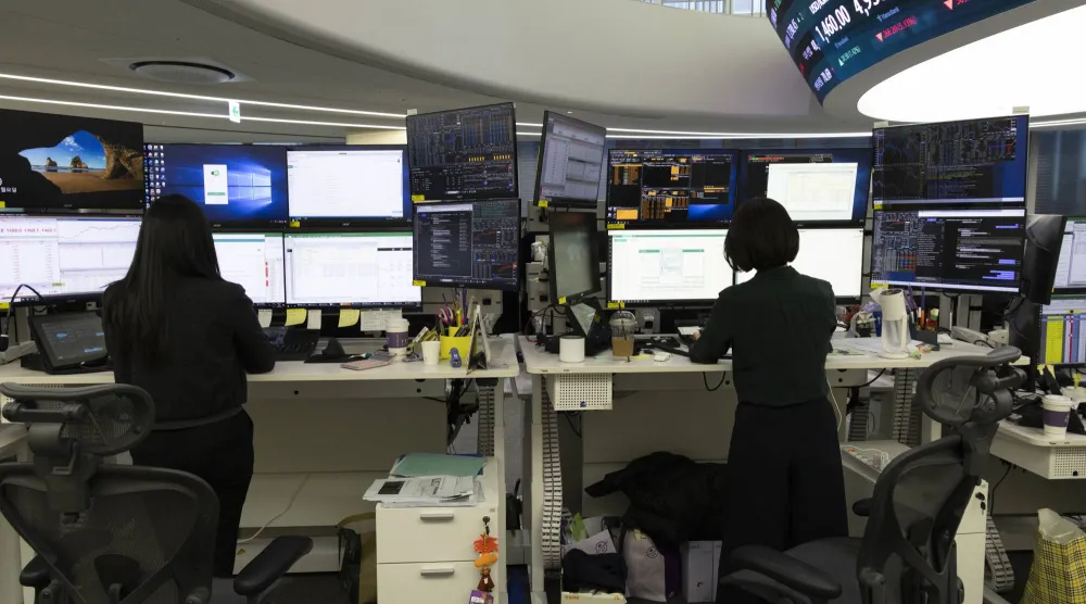 يعمل متداولون كوريون جنوبيون أمام شاشات تعرض مؤشرات الأسهم ببنك هانا في سيول (إ.ب.أ)