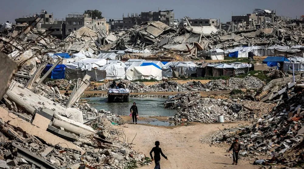 Boys walk past the rubble of destroyed buildings in the Jabalia camp for Palestinian refugees in the northern Gaza Strip on February 8, 2026. (AFP) 