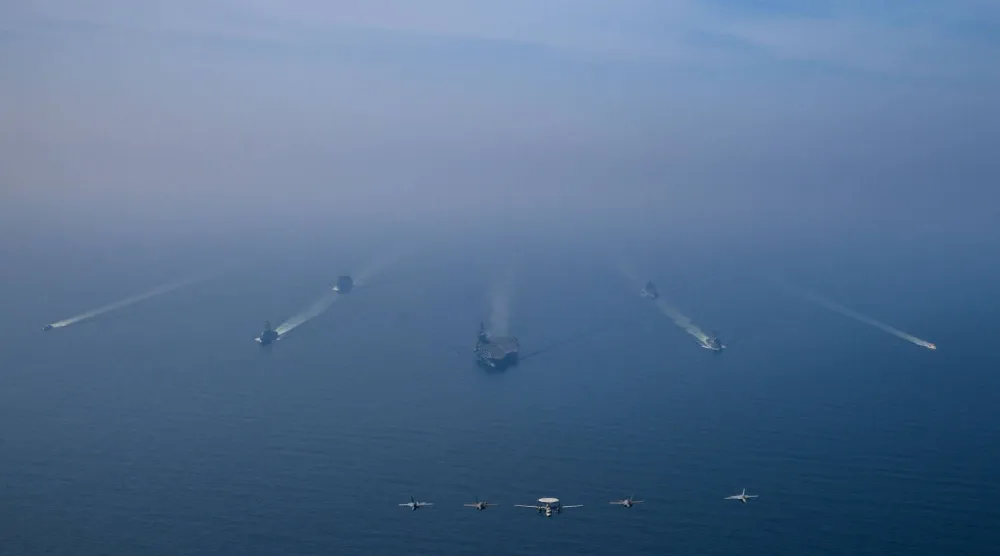 مجموعة حاملة الطائرات الأميركية «أبراهام لينكولن» ترافقها سفينتا إمداد عسكري وقطعتان من خفر السواحل الأميركي تبحر في بحر العرب في حين تحلّق طائرات الجناح الجوي التاسع فوق التشكيل في استعراض للقوة (سنتكوم)