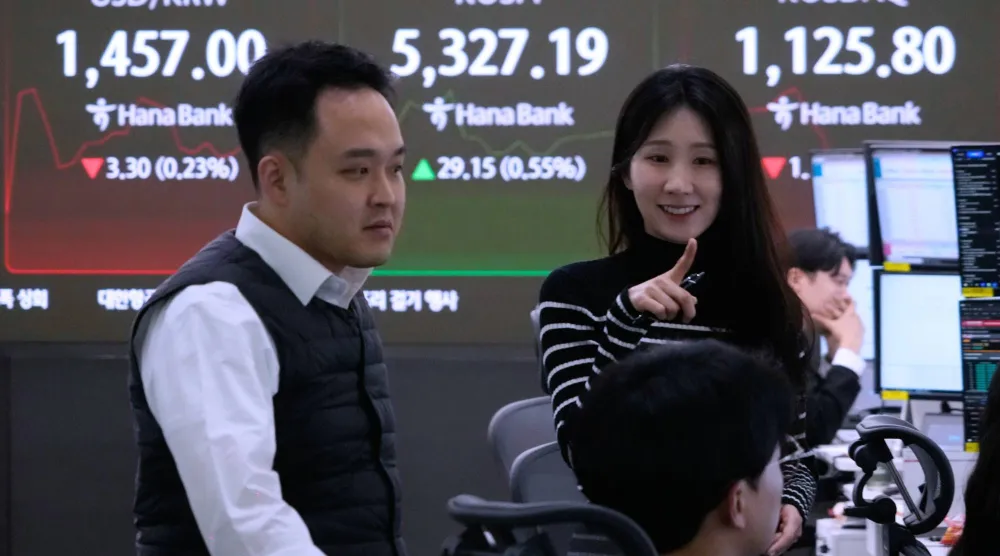 متداولو عملات أمام شاشة تعرض مؤشر «كوسبي» وسعر صرف الدولار مقابل الوون في مقر بنك هانا بسيول (أ.ب)