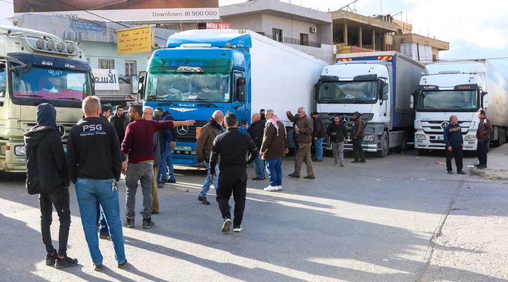 سائقو شاحنات لبنانية يقطعون الطريق عند نقطة المصنع الحدودية مع سوريا رفضاً للقرار السوري (أ.ف.ب)