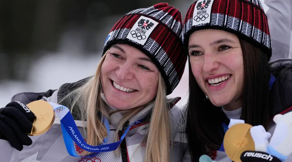 النمساويتان أريان ريدلر «يسار» وكاثارينا هوبر تحتفلان بذهبية الفرق (أ.ب)
