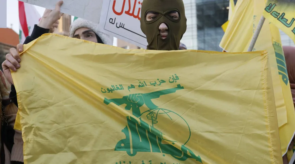 أحد مؤيدي «حزب الله» يلبس قناعاً وهو يحمل علم الحزب خلال احتجاج نظّمه الحزب تحت شعار «البلاد كلها مقاومة» أمام مقر لجنة الأمم المتحدة الاقتصادية والاجتماعية لغرب آسيا (الإسكوا) في بيروت 4 فبراير 2026 (إ.ب.أ)