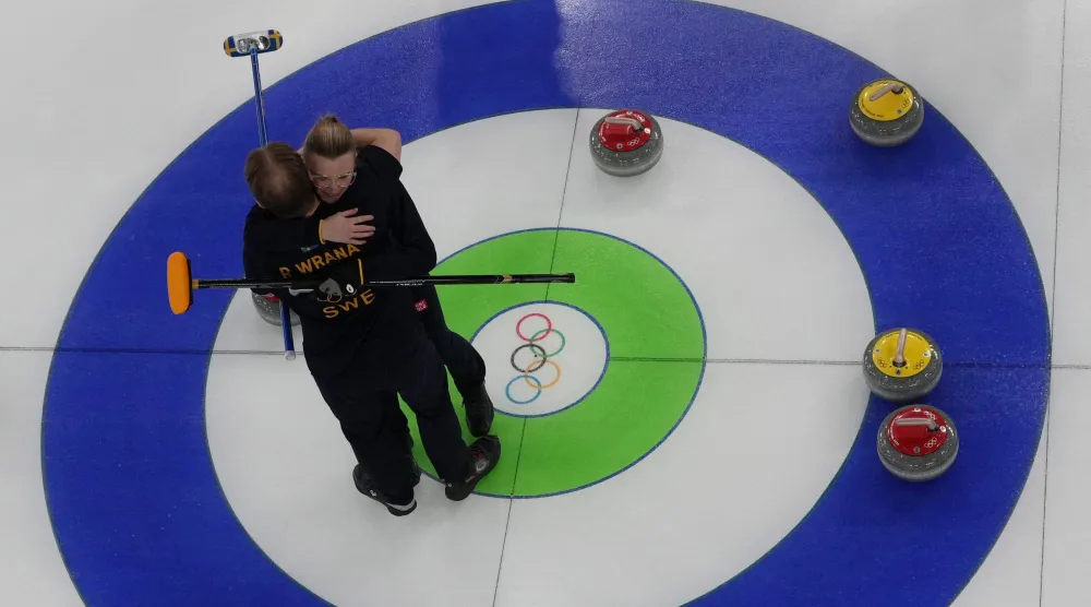 الشقيقان السويديان راسموس وإيزابيلا ورانا يحتفلان بالفوز بالزوجي المختلط للكيرلينج (رويترز)