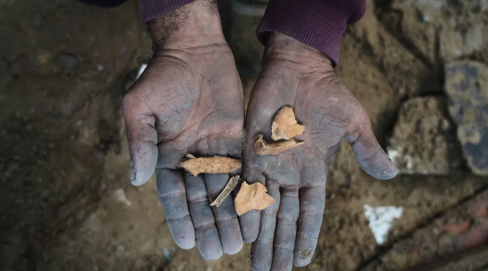 تظهر شظايا العظام أمام الكاميرا خلال عملية بحث عن رفات نعمة حماد التي لا تزال مدفونة تحت أنقاض منزلها الذي دمرته غارة جوية إسرائيلية في ديسمبر 2023 في مدينة غزة (أ.ب)
