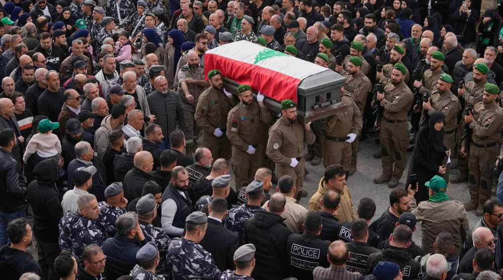 عناصر من الأمن الداخلي يحملون نعش زميلهم حسن جابر (38 عاماً) الذي قُتل يوم الاثنين مع ابنه علي (4 أعوام) بغارة جوية إسرائيلية بطائرة مسيّرة... خلال موكب جنازتهما في قرية يانوح جنوب لبنان يوم الثلاثاء (أ.ب)