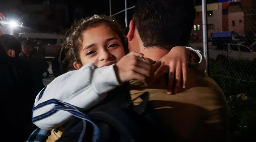 فلسطيني يحمل طفلة بينما يصل الفلسطينيون القادمون من معبر رفح الحدودي إلى مستشفى ناصر في خان يونس جنوب قطاع غزة يوم 9 فبراير الحالي (رويترز)