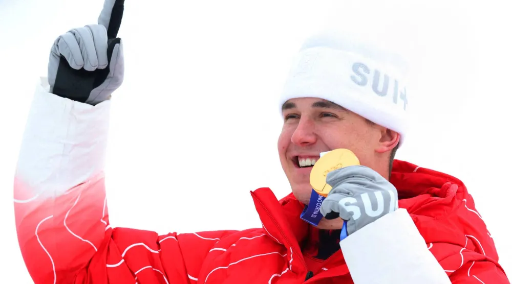 السويسري فرانيو فون ألمن يحتفل على منصة التتويج بعد فوزه بالميدالية الذهبية (رويترز)