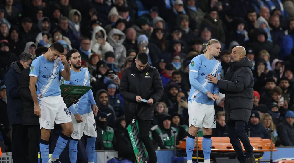 بيب غوارديولا يتحدث مع هالاند (رويترز)