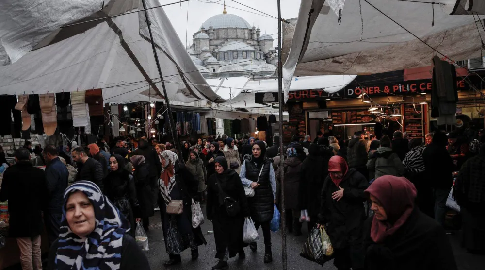 يتسوَّق الناس في سوق محلية بإسطنبول (رويترز)