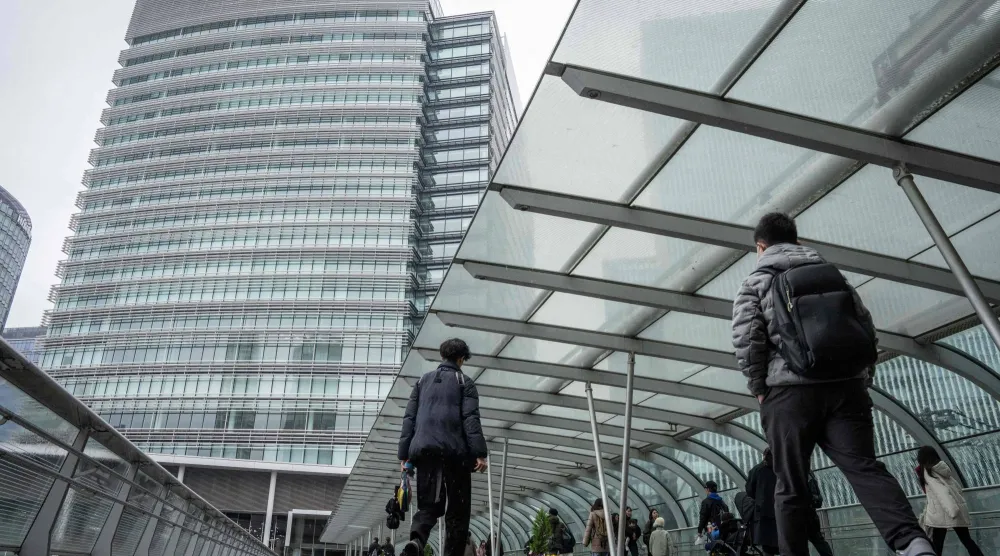 مشاة في أحد الأحياء المالية بمدينة يوكوهاما اليابانية (أ.ف.ب)