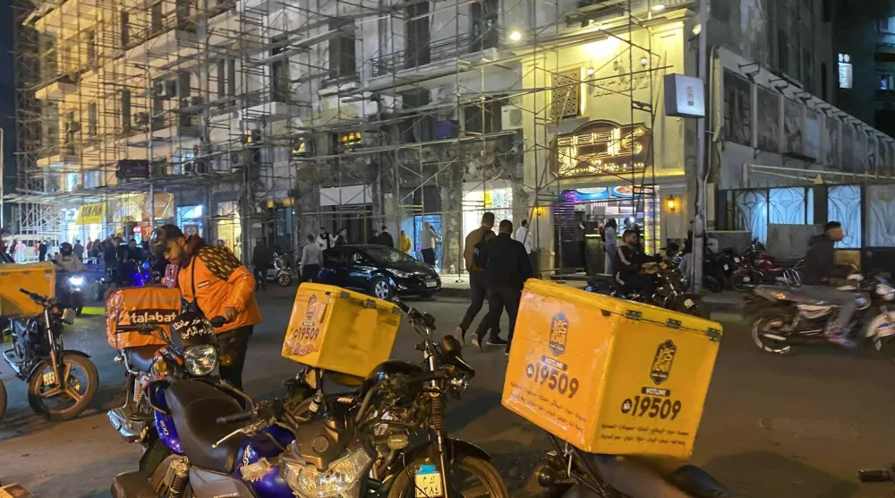 الشاب كريم ياسر خلال انتظاره لطلب من مطعم لتوصيله (الشرق الأوسط)