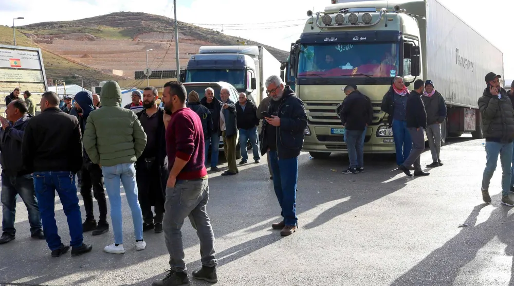 سائقو شاحنات لبنانية يعتصمون عند نقطة المصنع الحدودية مع سوريا اعتراضاً على قرار سوري يمنع شاحناتهم من دخول أراضيها (أ.ف.ب) 
