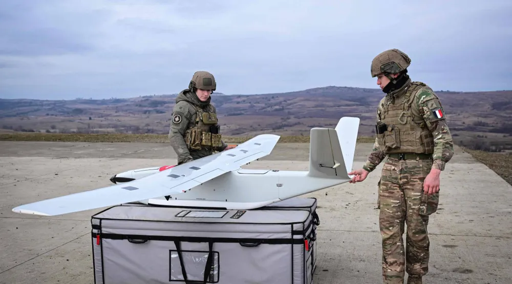 جنديان فرنسيان يُشغلان طائرة مراقبة مُسيرة خلال تدريبات في رومانيا (أ.ف.ب)