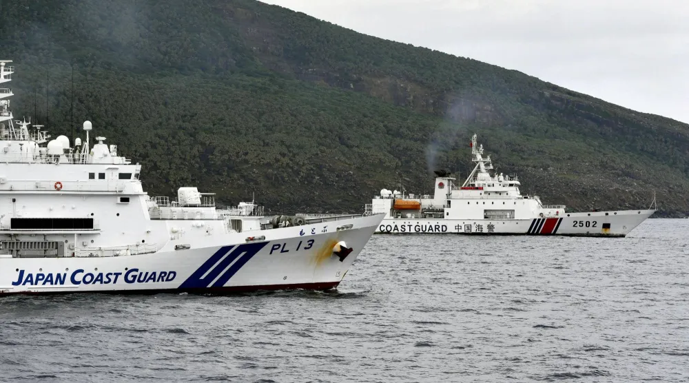 سفينة تابعة لخفر السواحل الصينية تبحر بالقرب من أخرى لخفر السواحل اليابانية قبالة جزيرة متنازع عليها (أرشيفية - رويترز)