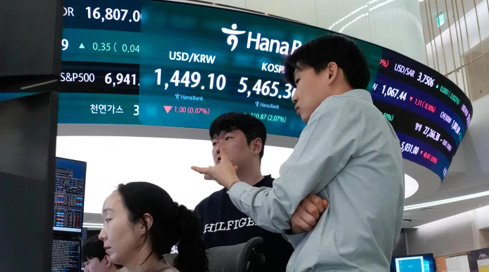 متداولون بالقرب من شاشة تعرض مؤشر «كوسبي» وسعر صرف الدولار مقابل الوون في مقر بنك هانا في سيول (أ.ب)