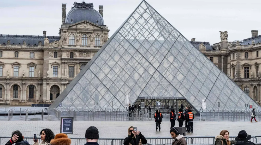 سياح يقفون أمام اللوفر في باريس (أ.ف.ب)