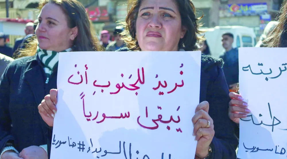 سوريون يرفعون لافتات في «ساحة الكرامة» المركزية بمدينة السويداء في جنوب سوريا 25 فبراير 2025 (أ.ف.ب)