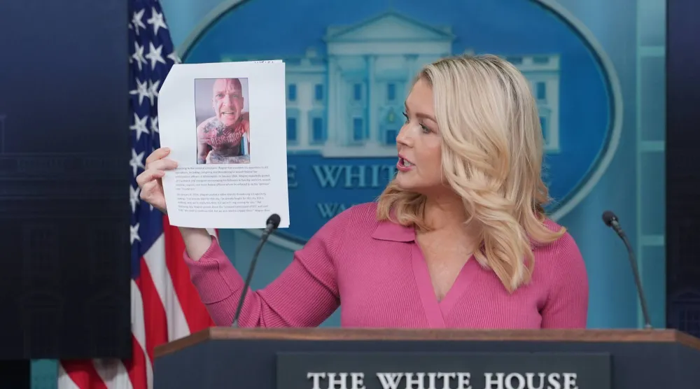 كارولين ليفيت المتحدثة باسم البيت الأبيض تحمل صورة أحد المجرمين الذين تريد إدارة ترمب ترحيلهم من الولايات المتحدة وتدافع خلال مؤتمر صحافي بالبيت الأبيض 5 فبراير 2026 عن سياسات الإدارة الأميركية في مجال الهجرة وترحيل المهاجرين غير الشرعيين (أ.ب)