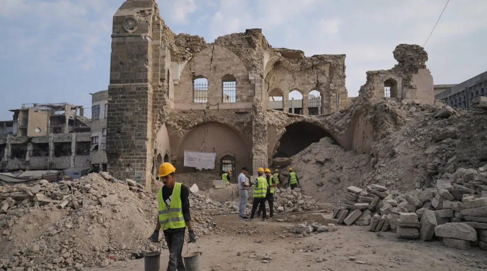 عمال يقومون بأعمال ترميم ويبحثون عن قطع أثرية مفقودة في قصر الباشا بمدينة غزة بعد أن ألحقت به غارة إسرائيلية أضراراً خلال الحرب (أ.ب)