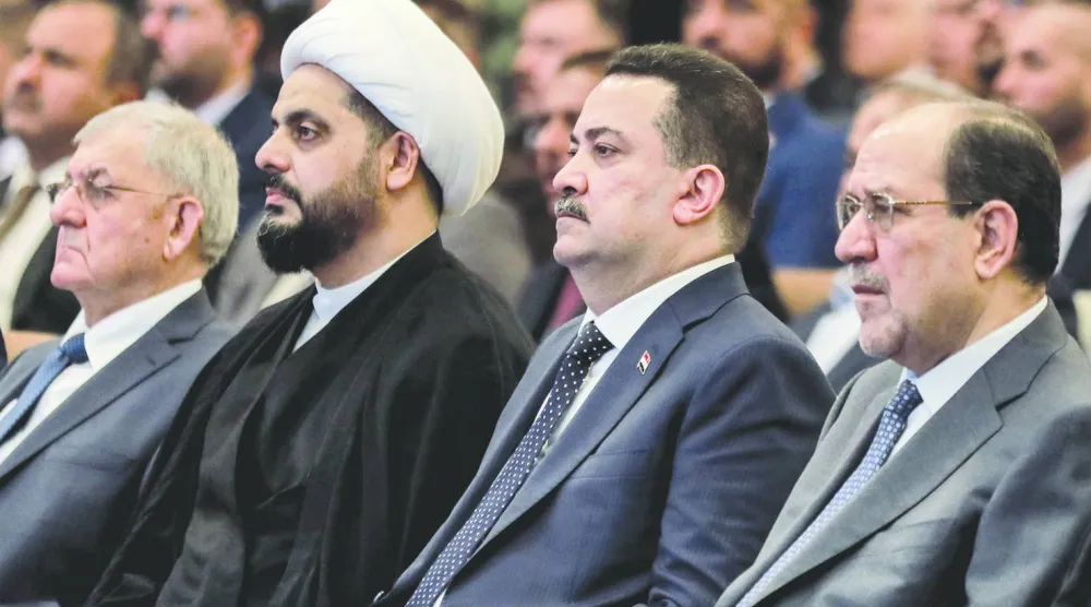 رئيس الوزراء العراقي محمد شياع السوداني وإلى يساره في الصورة نوري المالكي (أ.ف.ب)