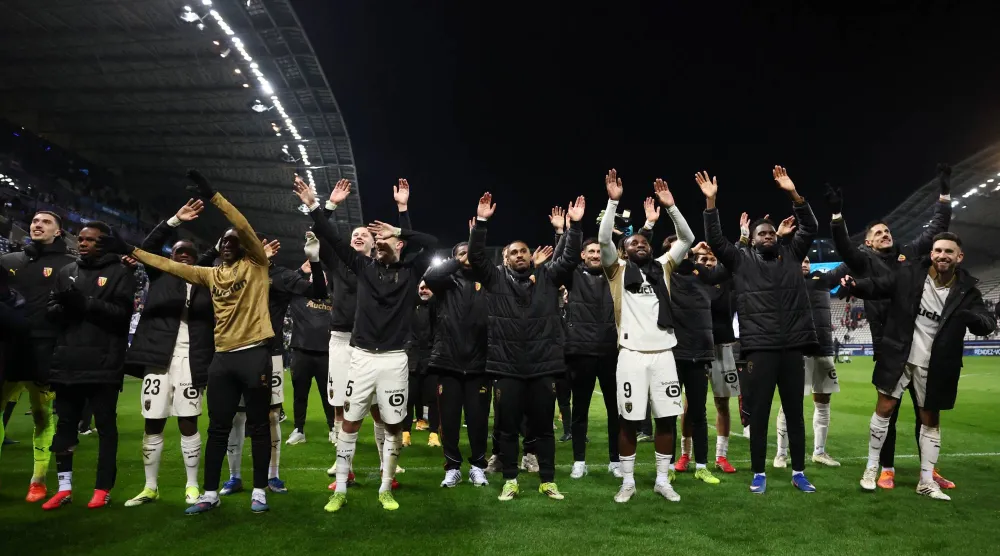 لاعبو لانس يحتفلون مع جماهيرهم بعد الفوز (رويترز)