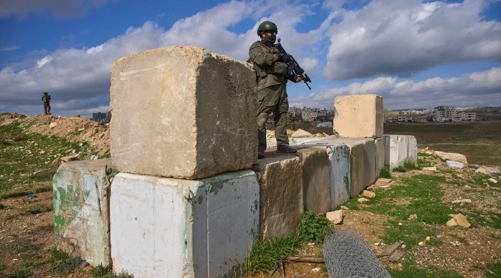 جنود إسرائيليون يقفون حراساً خلال حفل افتتاح مستوطنة ياتسيف اليهودية قرب بيت ساحور في الضفة الغربية يوم الاثنين (أسوشييتد برس)