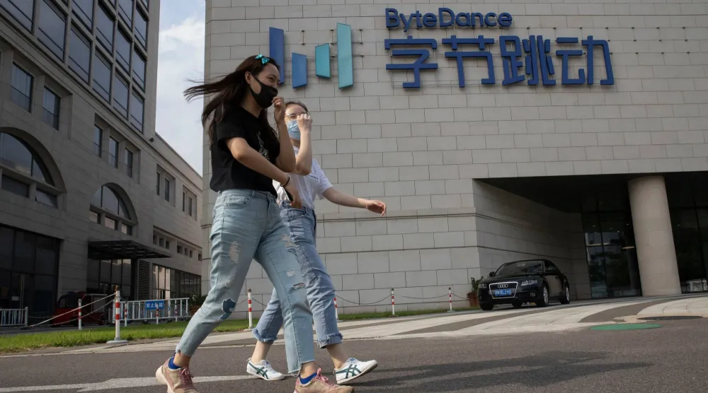 سيدتان تمران أمام مقر شركة «بايت دانس» في العاصمة الصينية بكين (أ.ب)