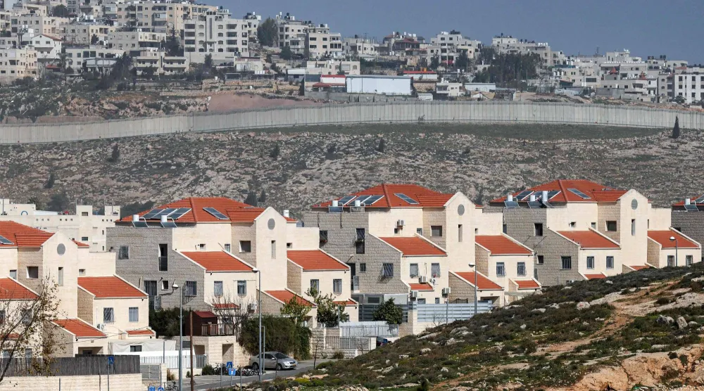 صورة من مستوطنة النبي يعقوب الإسرائيلية (في المقدمة) في المنطقة الشمالية من القدس الشرقية والجدار الإسرائيلي المثير للجدل الذي يفصل قرية الرام الفلسطينية (في الخلفية) في الضفة الغربية المحتلة 16 فبراير 2026 (أ.ف.ب)