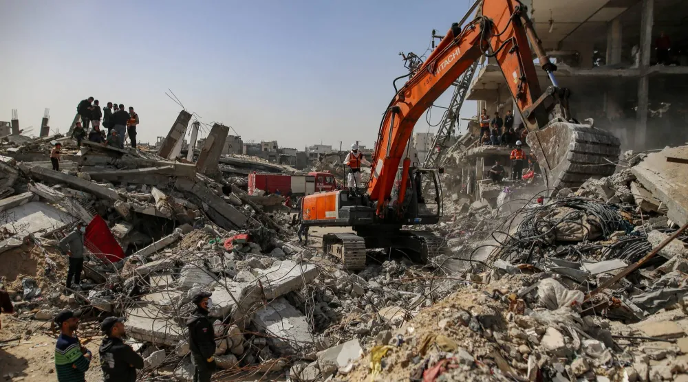 فرق «الدفاع المدني» الفلسطيني تعمل على انتشال رفات 67 فرداً من عائلة أبو نصر من تحت أنقاض منزلهم بعد تدميره في غارة جوية إسرائيلية ببيت لاهيا شمال مدينة غزة - 15 فبراير 2026 (إ.ب.أ)