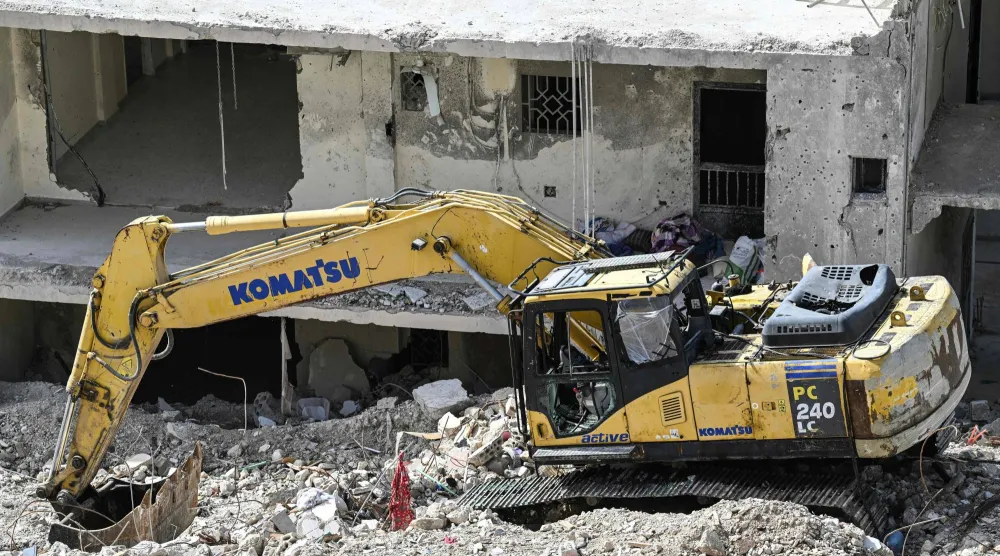 حفارة متضررة تقف على أنقاض مبنى تعرّض لضربة جوية إسرائيلية في قرية قناريت جنوب لبنان... 16 فبراير 2026 (أ.ف.ب)