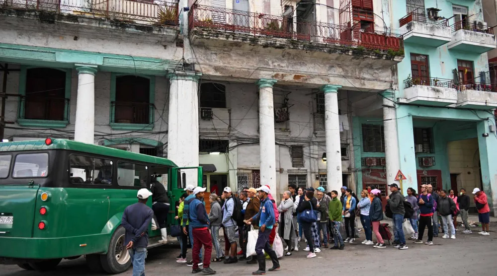 كوبيون يصطفون للصعود إلى حافلة نقل خاصة في هافانا وسط تزايد أزمة الطاقة جراء الضغوط الأميركية 6 فبراير 2026 (أ.ف.ب) 