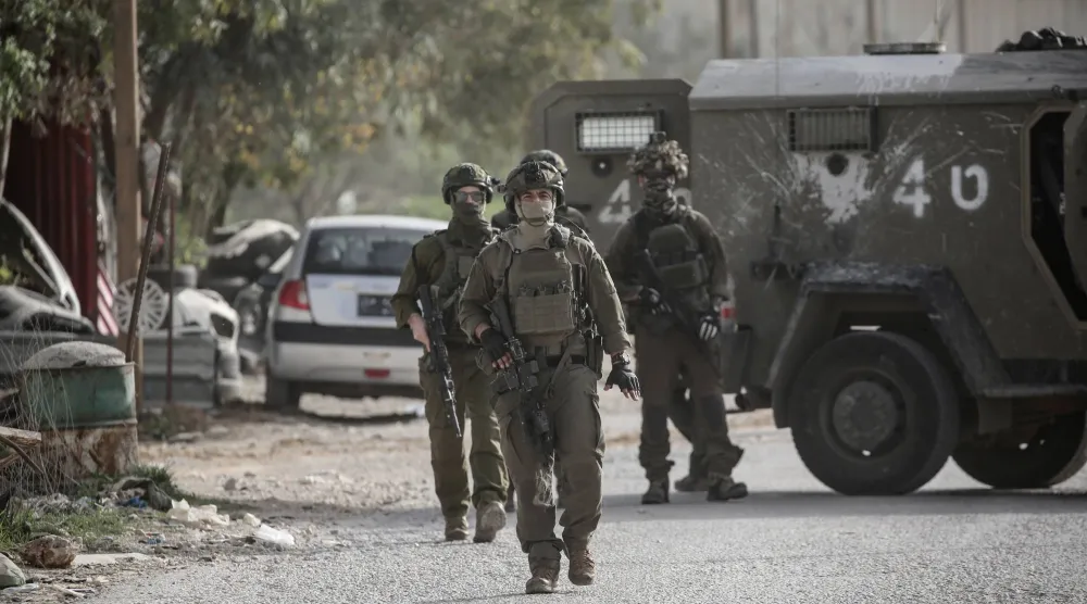 جنود إسرائيليون يتخذون إجراءات أمنية أثناء قيام الجيش بهدم متجر فلسطيني وورشة لتصليح السيارات بدعوى عدم حصولهما على التراخيص اللازمة بالقرب من حاجز عورتا (د.ب.أ)