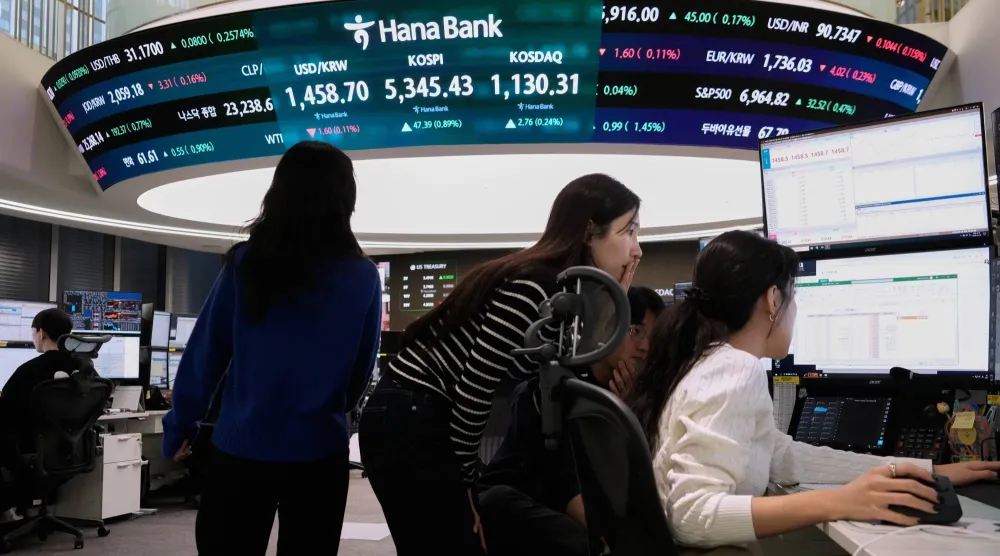 متداولو عملات يراقبون شاشة تعرض مؤشر «كوسبي» وسعر صرف الدولار مقابل الوون داخل بنك هانا في سيول (أ.ب)