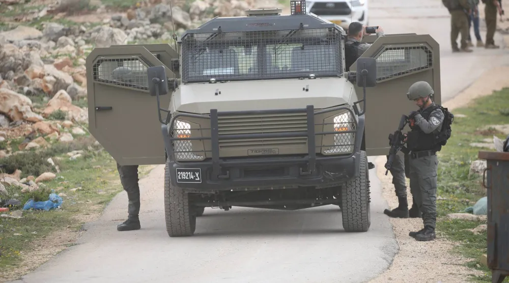 جنود إسرائيليون يؤمّنون الجرافات الإسرائيلية أثناء هدمها منزلاً فلسطينياً في نابلس بالضفة الغربية يوم الاثنين (د.ب.أ)