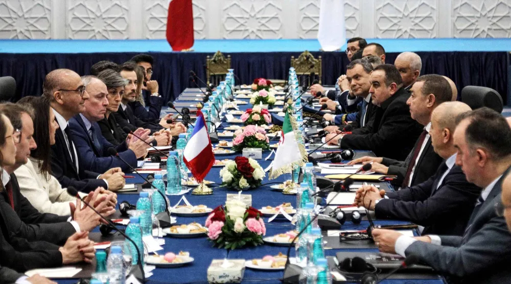 وزير الداخلية الفرنسي والوفد المرافق له خلال لقائه نظيره الجزائري (أ.ف.ب)