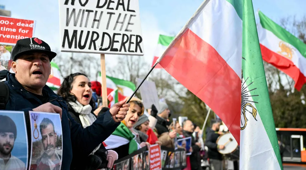 متظاهرون مناهضون للسلطات الإيرانية يرفعون لافتات وصوراً أمام مكتب الأمم المتحدة قبيل بدء المحادثات النووية غير المباشرة بين الولايات المتحدة وإيران في جنيف بوم 17 فبراير 2026 (أ.ف.ب)